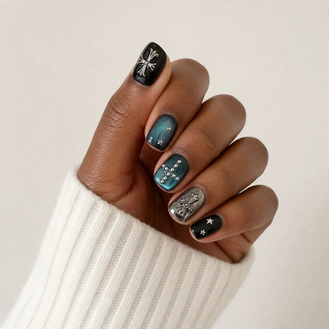 Cross Current black and teal manicure on one medium-brown hand