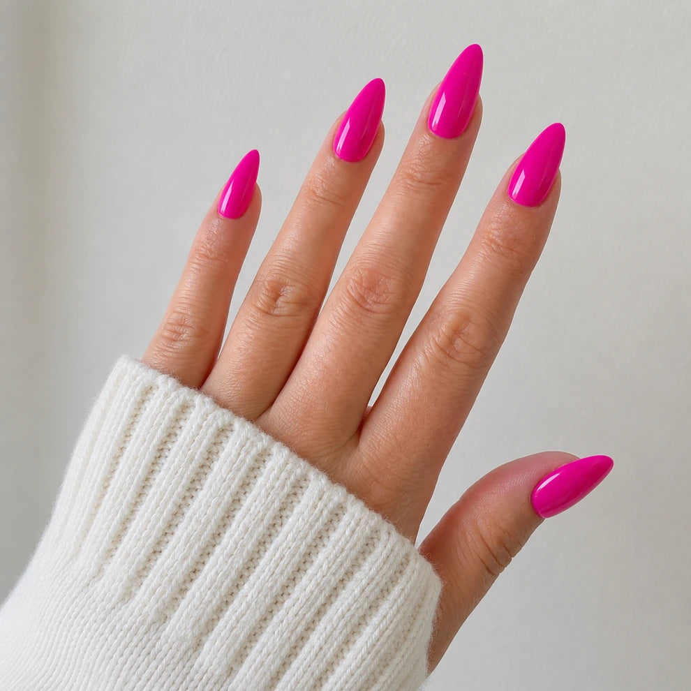 Dragonfruit Crush medium almond hot pink press-on nails shown on a raised open hand