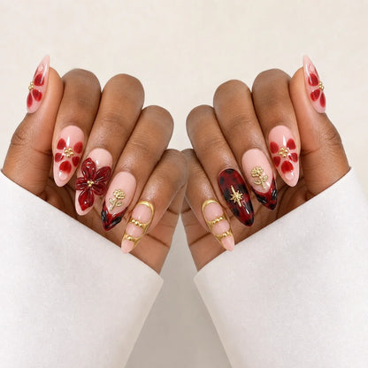 Crimson Keepsake wine-red and gold manicure on two medium-brown hands