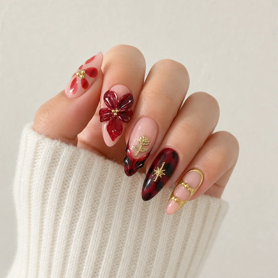 Crimson Keepsake floral press-on manicure on one softly curled hand