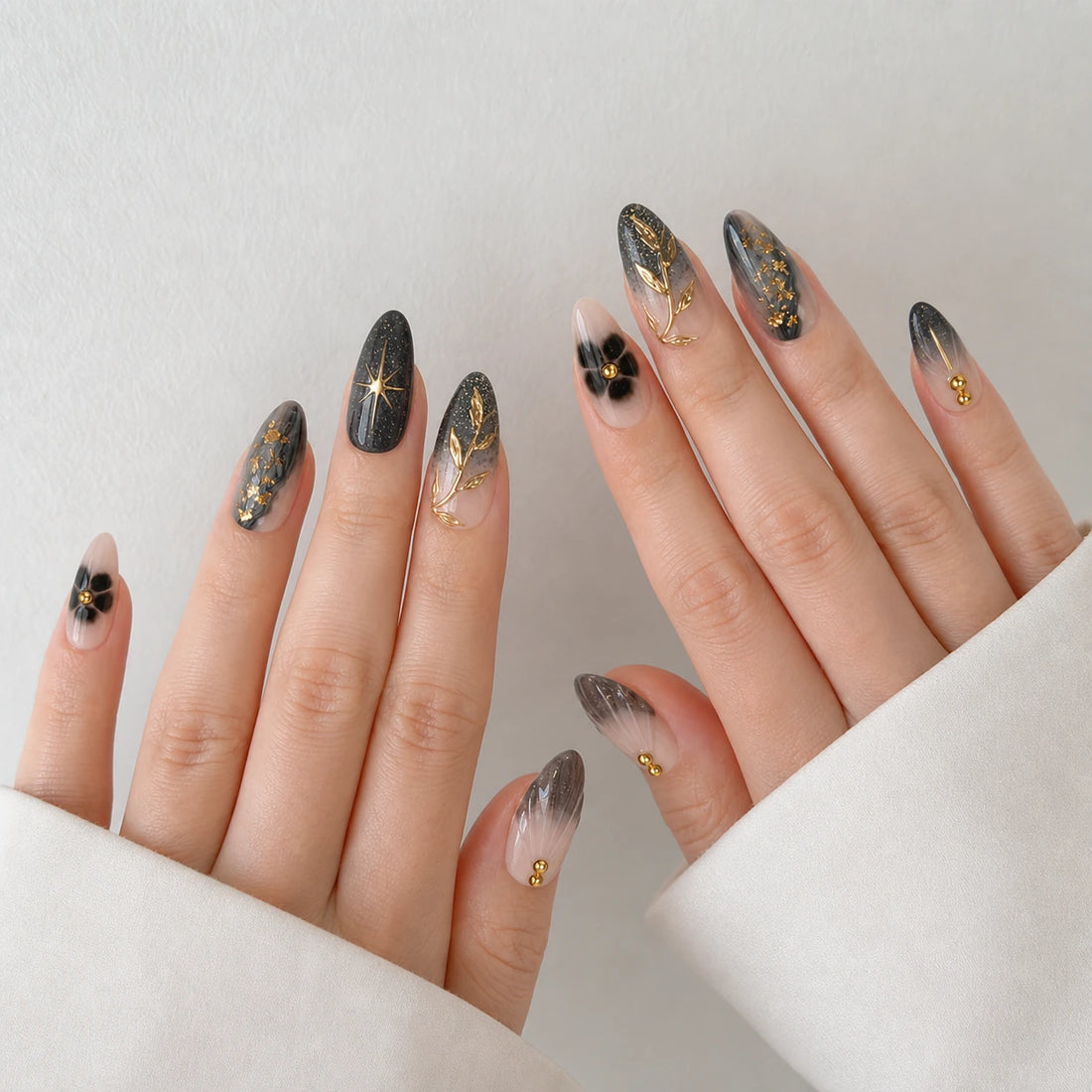 Astral Petal celestial botanical medium almond nails on two open light-skinned hands