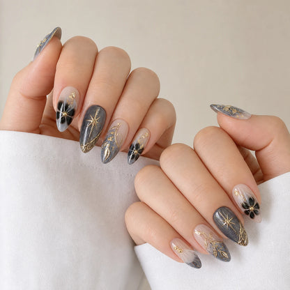 Astral Petal celestial botanical medium almond manicure on two softly curled light-skinned hands
