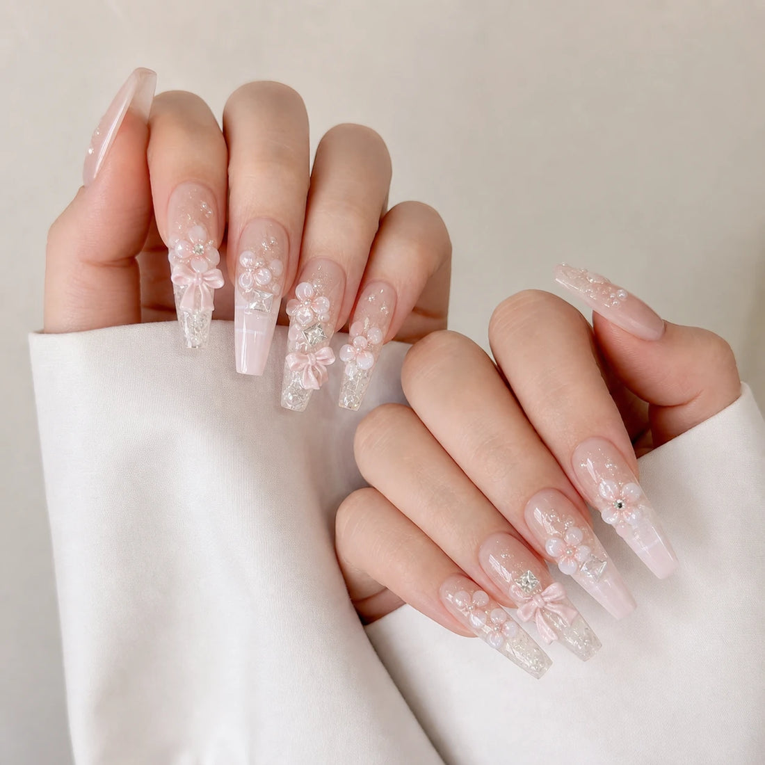 Blossom Sonata blush flower manicure on two softly curled light-skinned hands