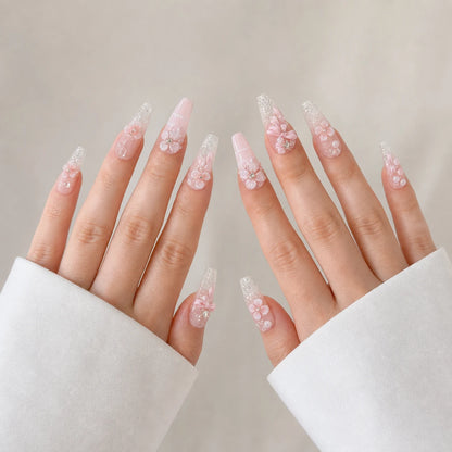 Blossom Sonata long coffin floral nails on two open light-skinned hands