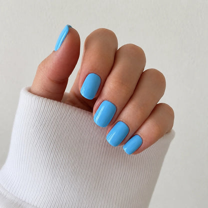 Bluebell Glaze glossy short square sky blue press-on nails in an angled hand view