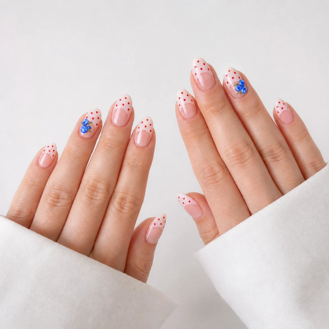 Blueberry Polka short almond press-on nails on two open hands