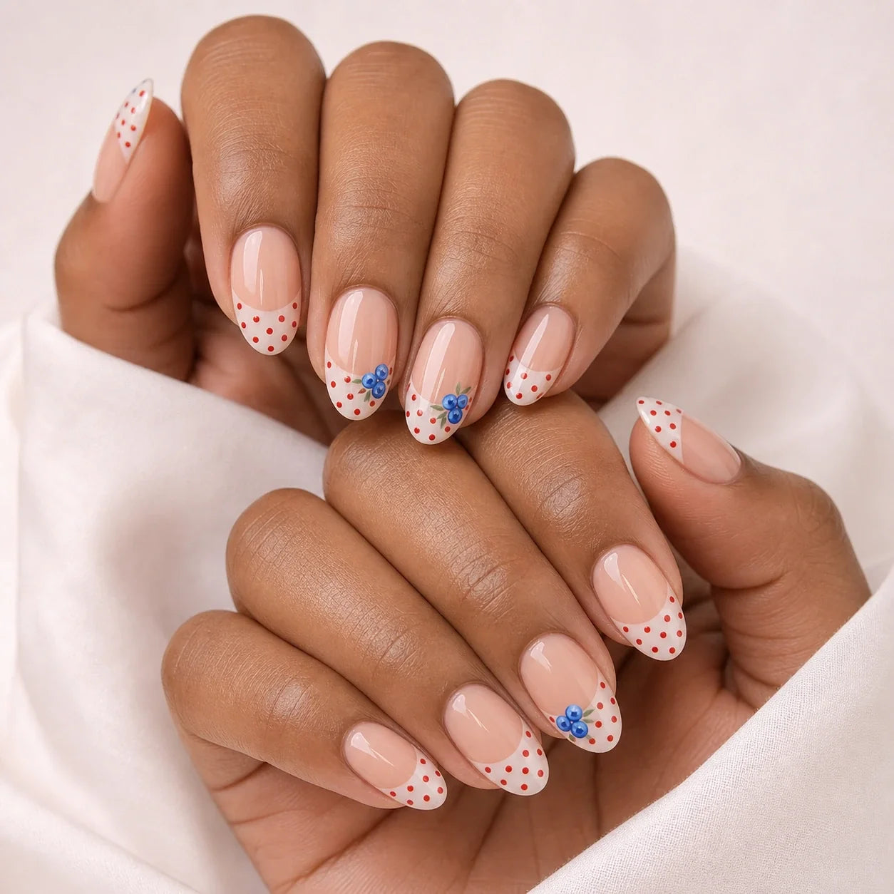 Blueberry Polka fruit nails on two medium-brown hands