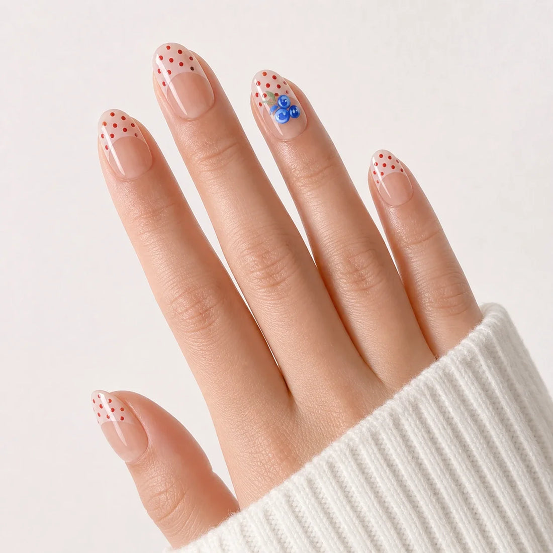 Blueberry Polka red dot nails on one open hand