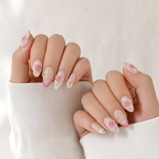 Blush Floralia medium almond floral press-on nails on two softly curled hands