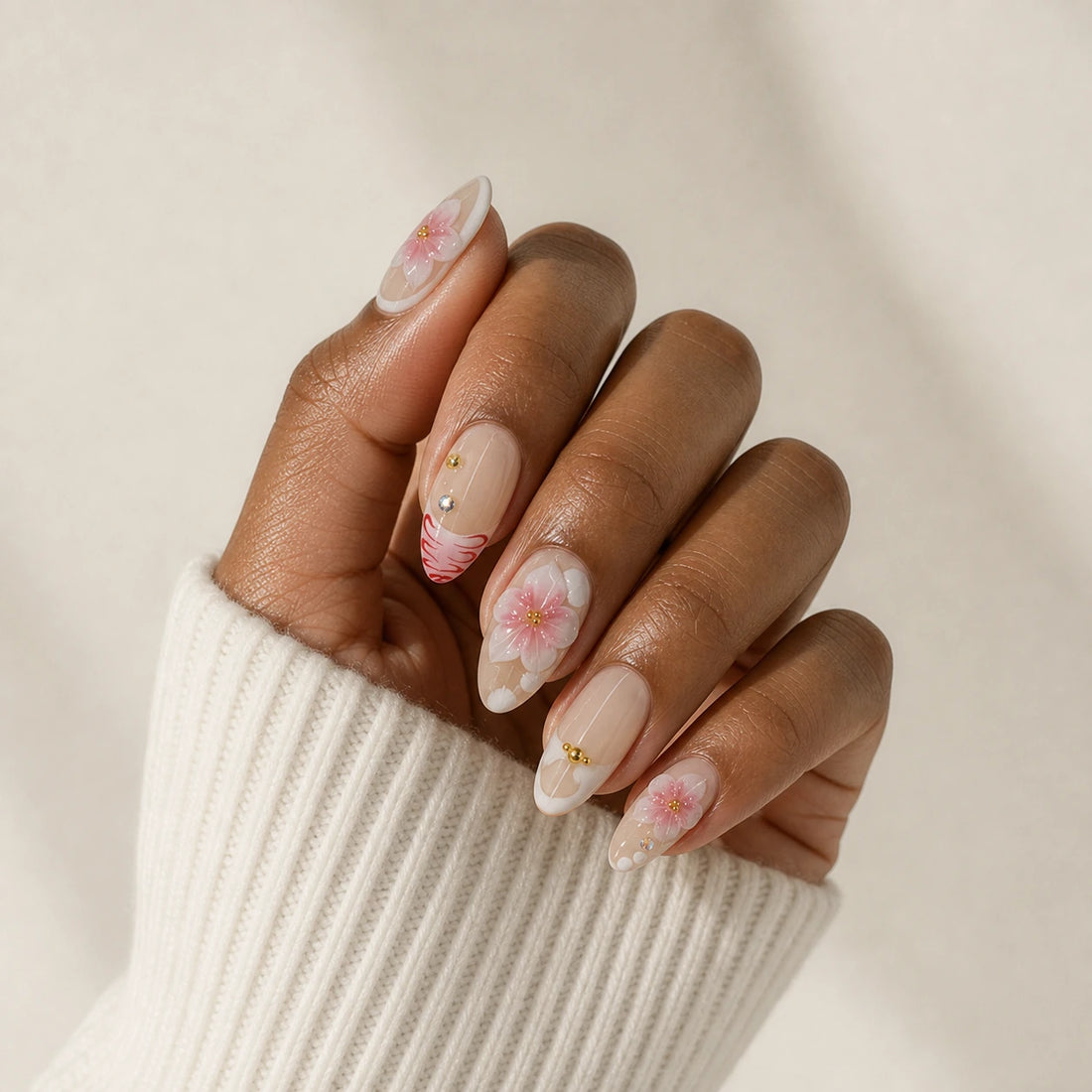 Blush Floralia medium almond floral press-on nails on one medium-brown hand