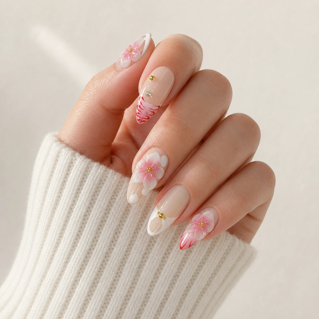 Blush Floralia medium almond floral press-on nails on one curled hand, previous version