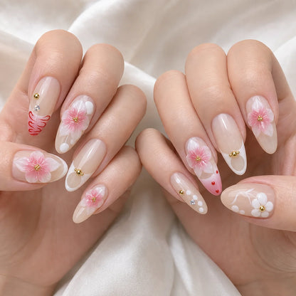 Blush Floralia medium almond floral press-on nails on two softly curled hands, new option