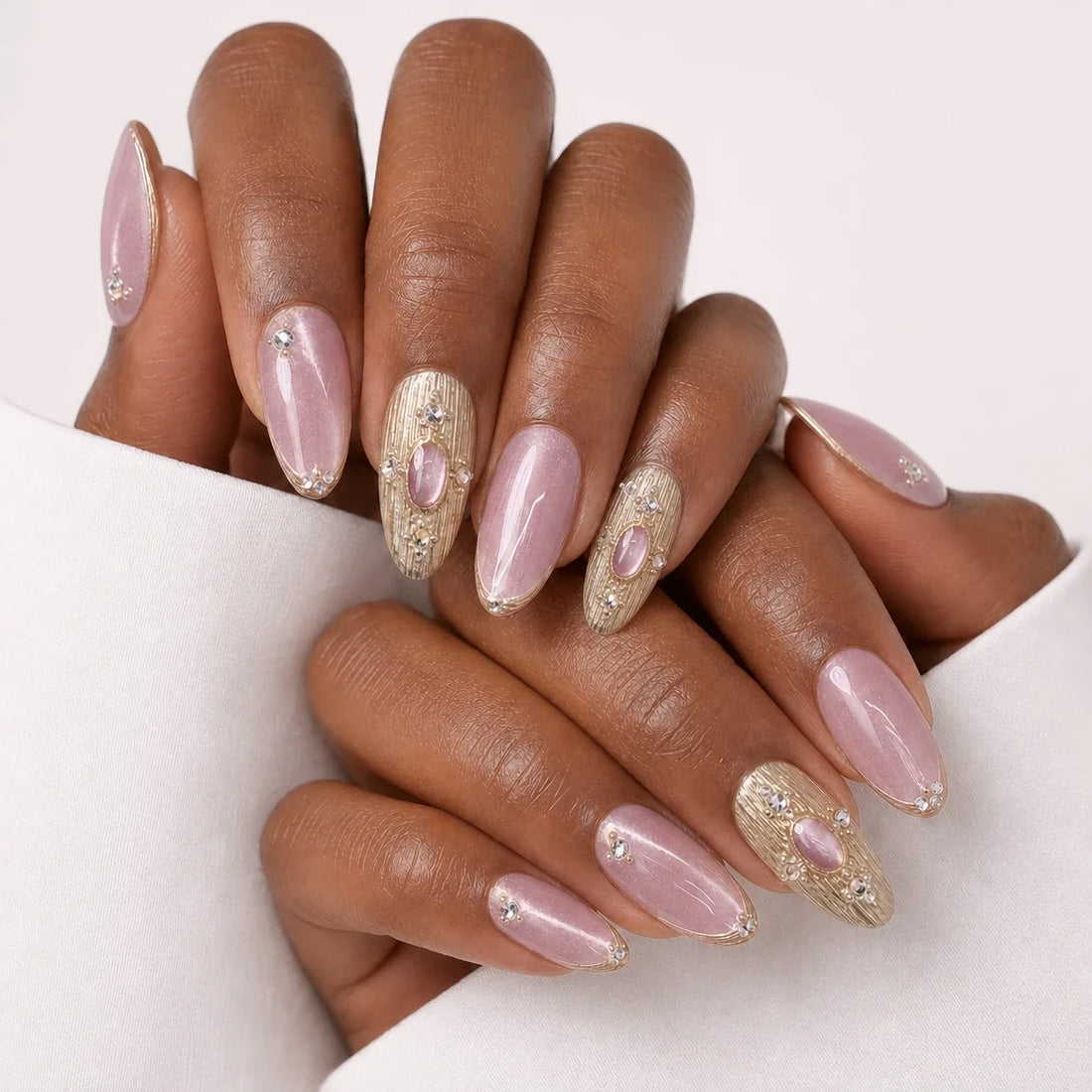 Champagne Oracle blush and gold manicure on two medium-brown hands