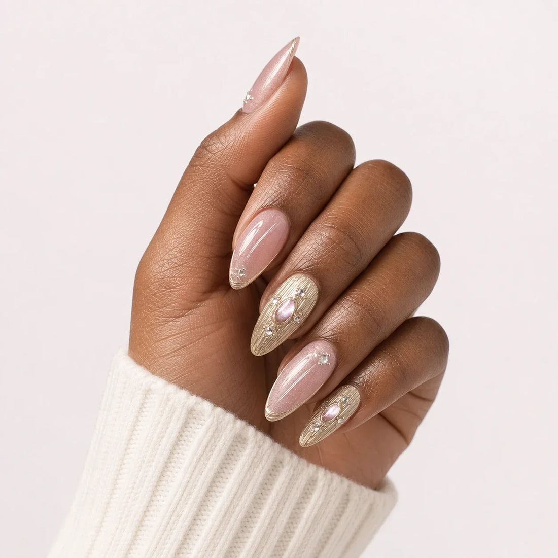 Champagne Oracle medium almond manicure on one medium-brown hand