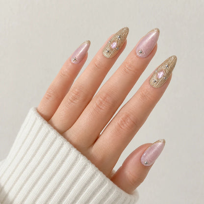 Champagne Oracle pink and champagne gold nails on one open light-skinned hand