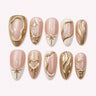 Champagne Zodiac gold chrome medium almond press-on nails on a pale blush background
