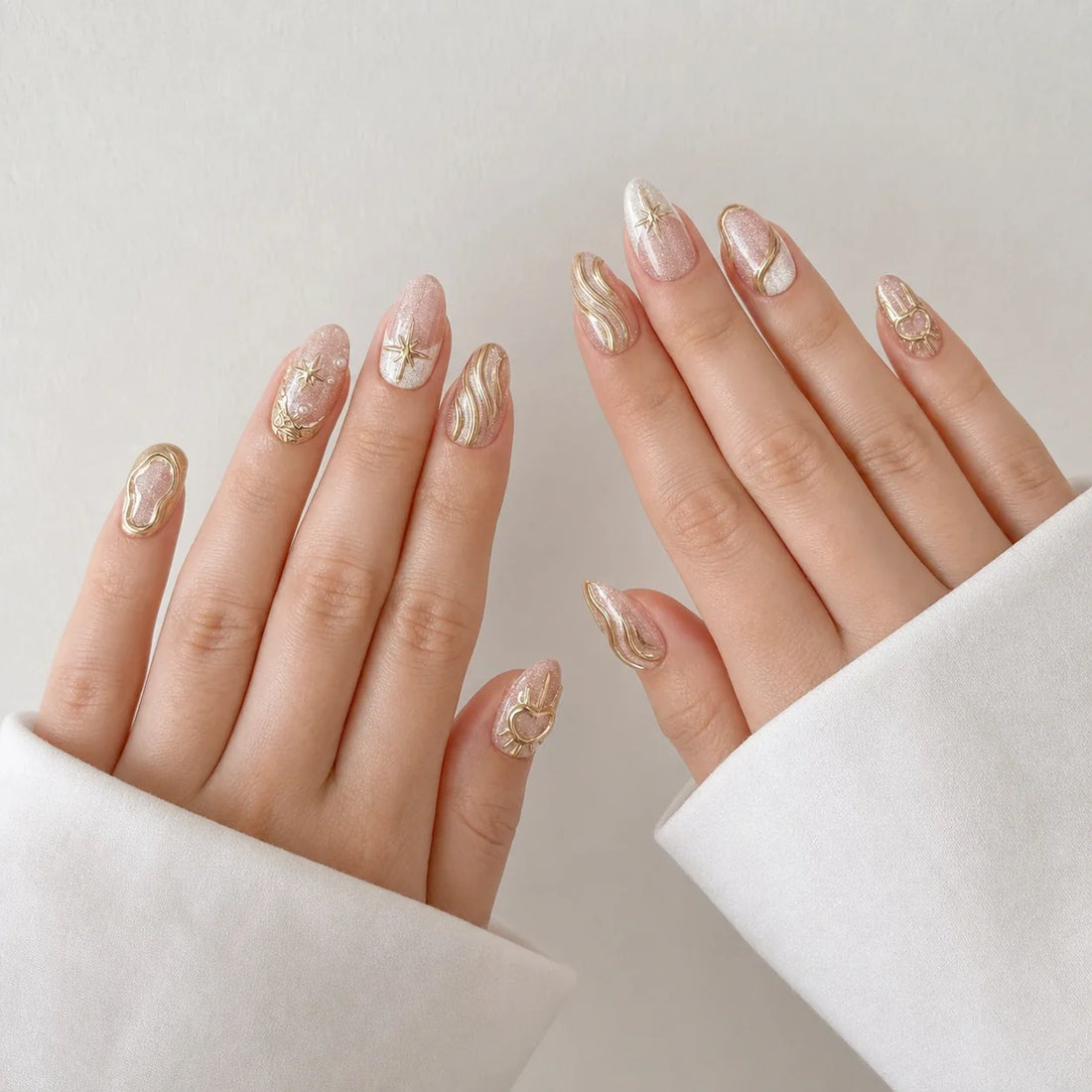 Champagne Zodiac gold celestial almond false nails on two open hands