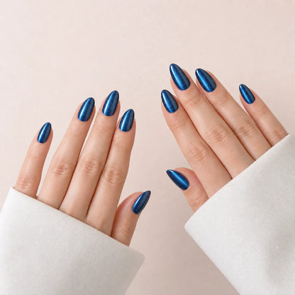 Cobalt Comet blue cat-eye medium almond press-on nails on two open hands