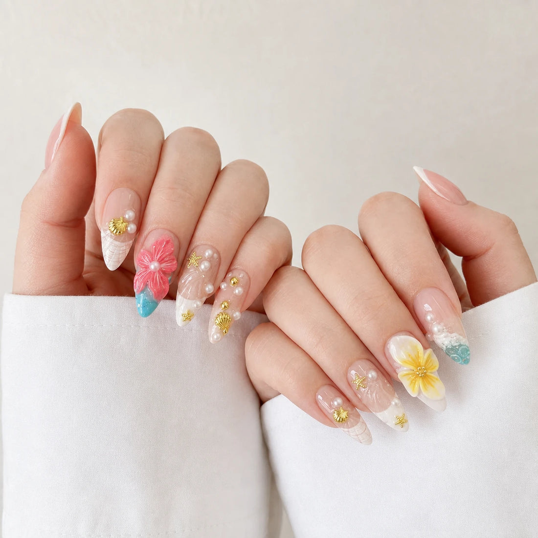 Coral Cabana tropical medium almond manicure on two softly curled light-skinned hands