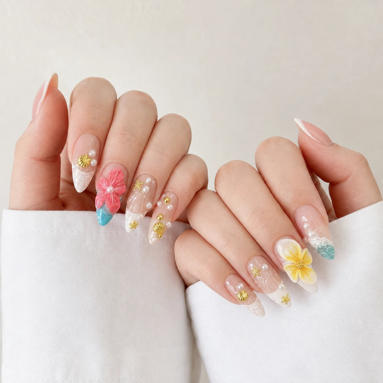 Coral Cabana tropical medium almond manicure on two softly curled light-skinned hands