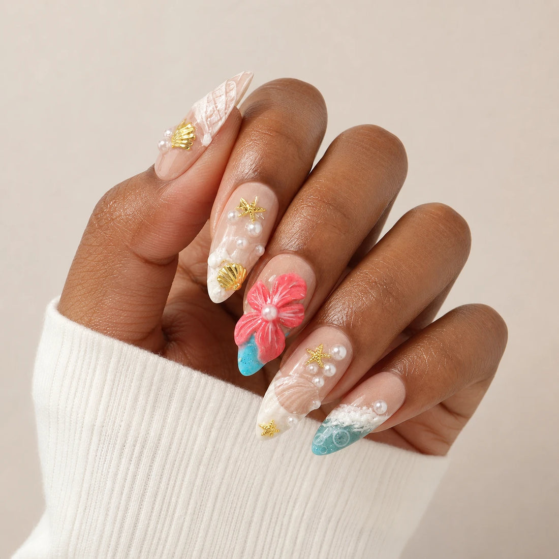 Coral Cabana coastal flower manicure on one medium-brown hand