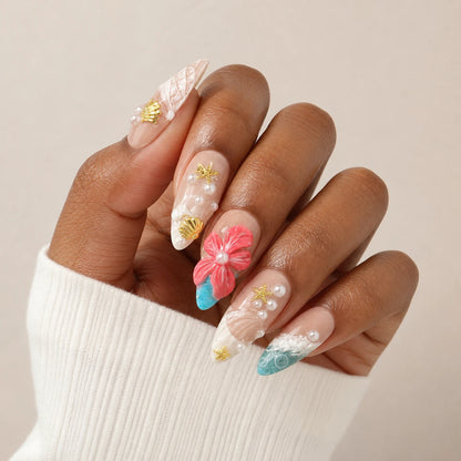 Coral Cabana coastal flower manicure on one medium-brown hand