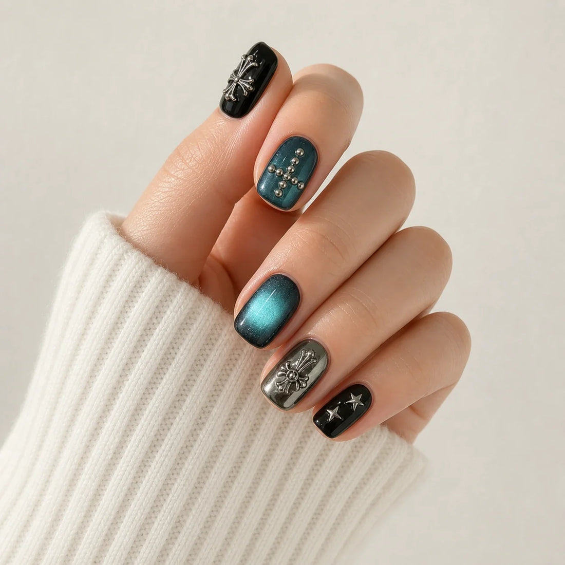 Cross Current teal cat eye manicure on one curled hand