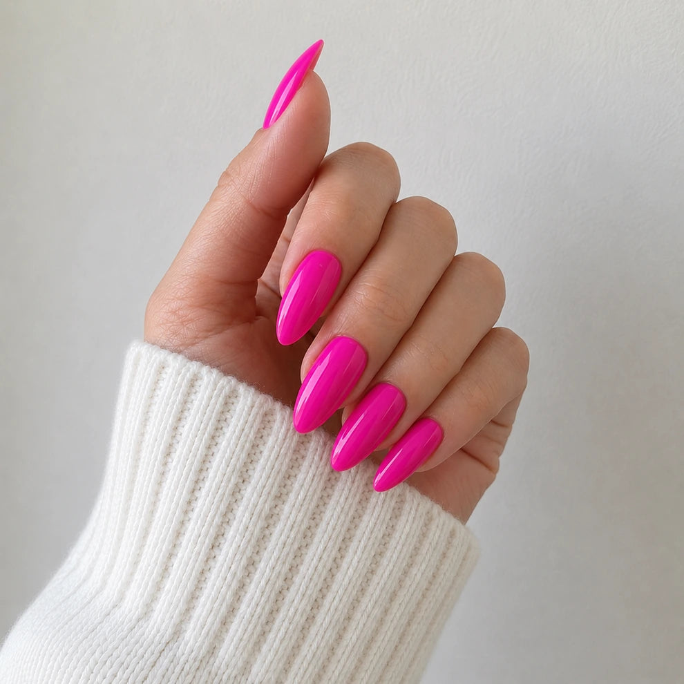 Dragonfruit Crush glossy hot pink almond press-on nails in an angled hand view