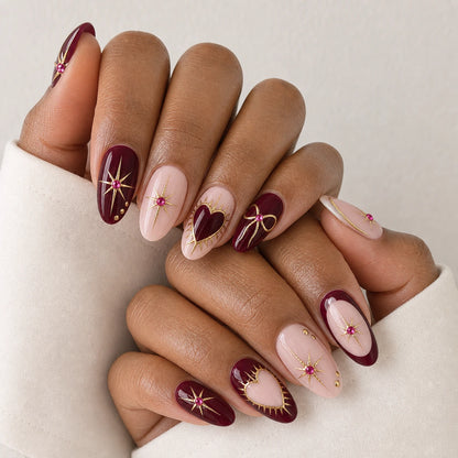 Garnet Wish burgundy blush and gold oval manicure on two medium-brown hands