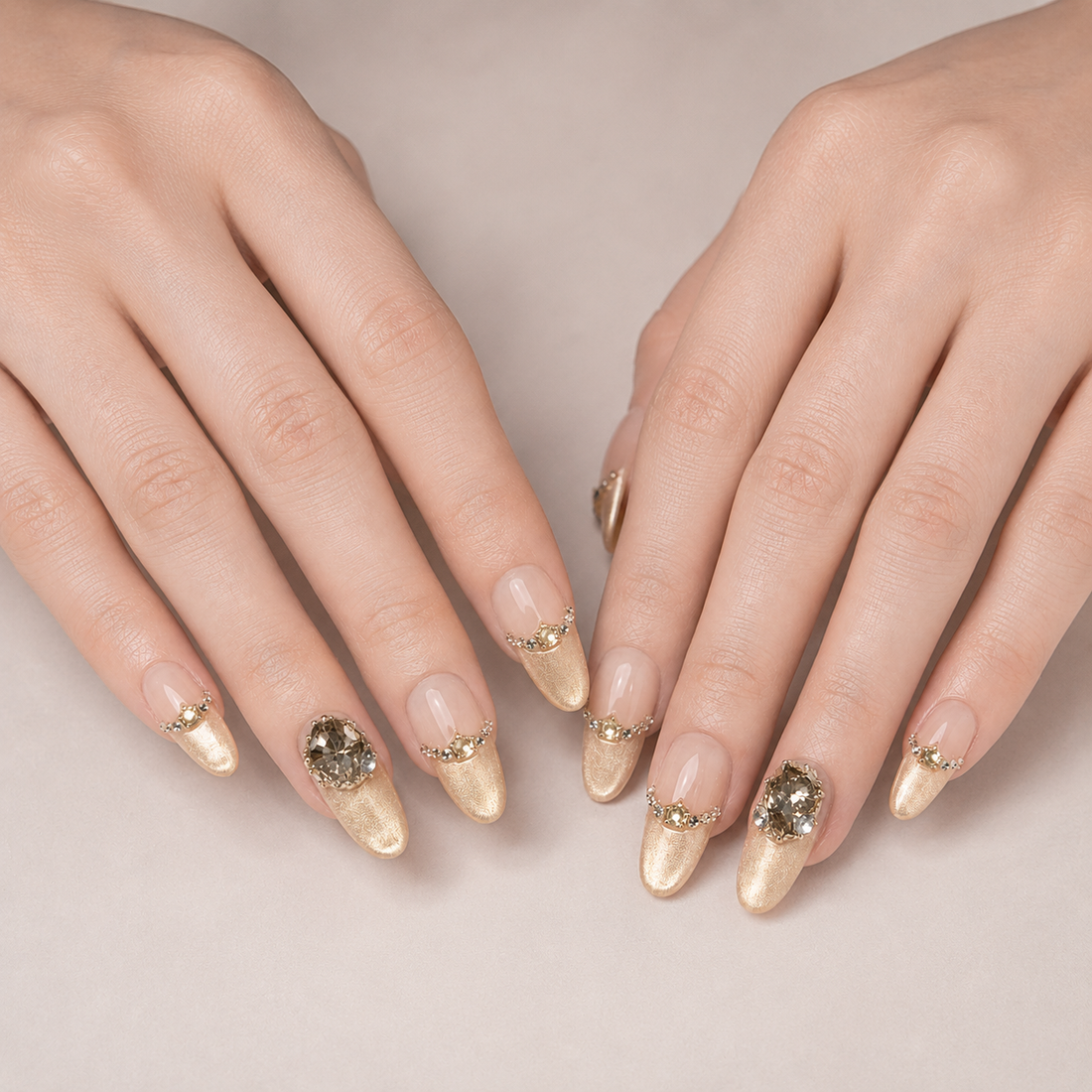 Two hands resting side by side in Gilded Cadence Long Oval press-on nails with curved rhinestone borders