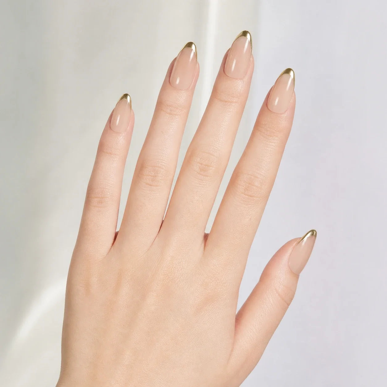 Gilded Whisper medium nude almond nails on one open hand
