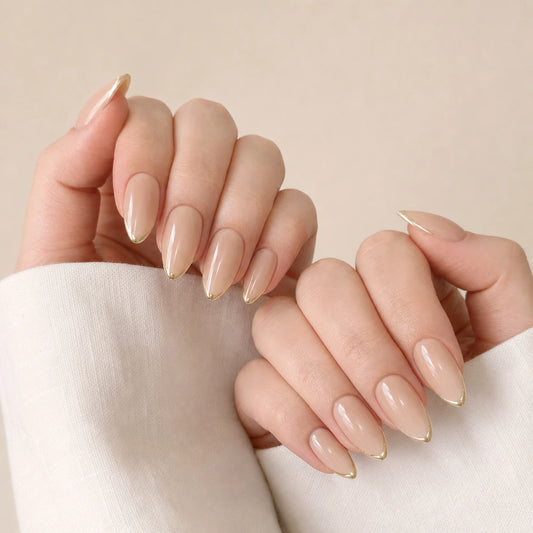 Gilded Whisper gold micro-French manicure on two softly curled light-skinned hands