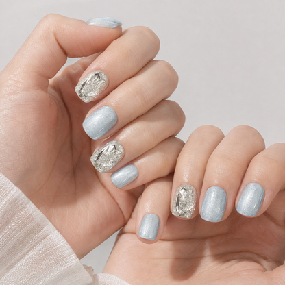 Close view of two light-skin hands wearing Glacier Prism short square icy blue press-on nails