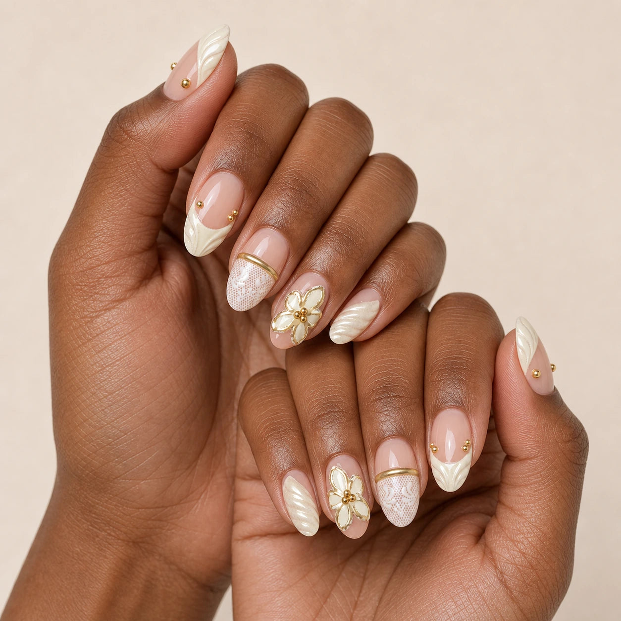 Ivory Brocade ivory gold manicure on two medium-brown hands