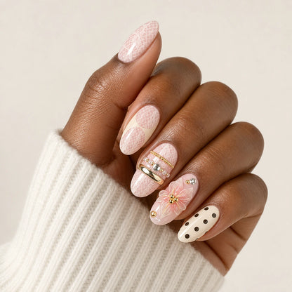 Lace Confetti pink ivory lace polka dot short almond press-on nails on one medium-brown hand