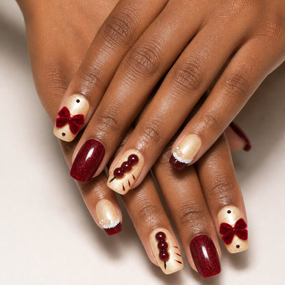 Burgundy Parcel press-on nails shown on dark-skinned two hands