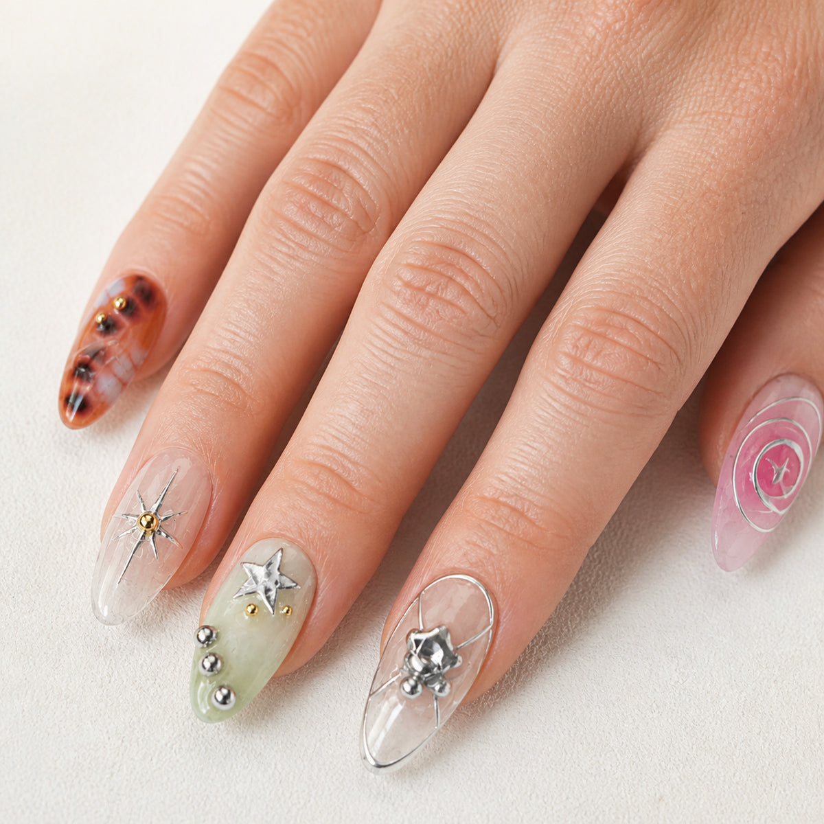 Cosmic Rosette press-on nails shown on light-skinned one hand