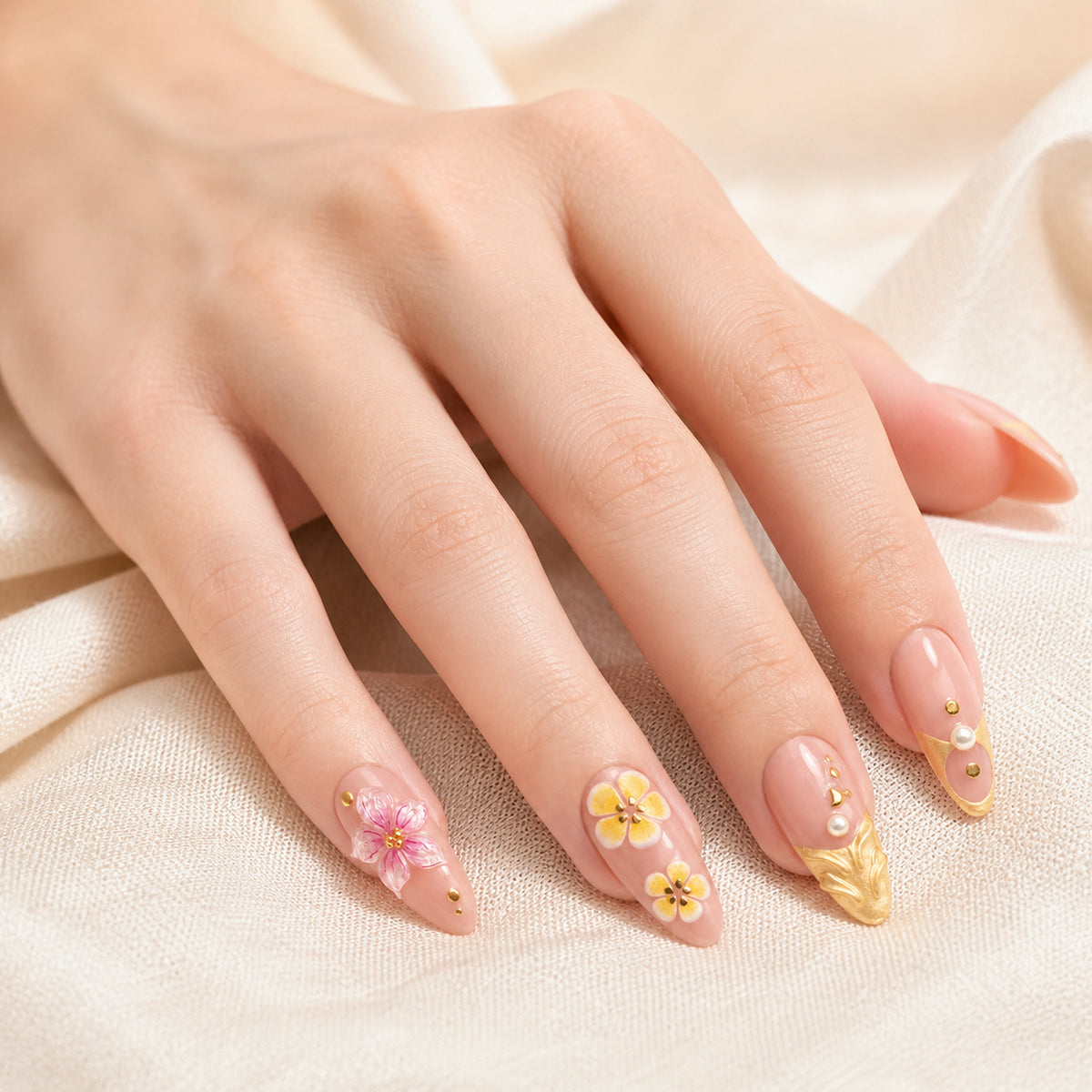 Gilded Hibiscus press-on nails shown on light-skinned one hand