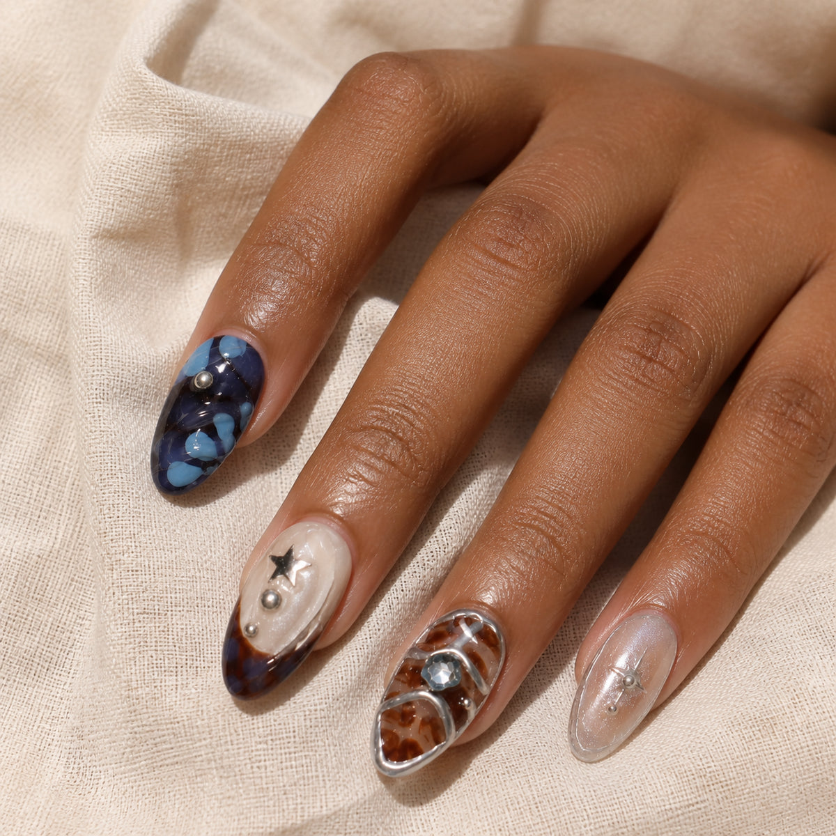 Mercury Mosaic press-on nails shown on dark-skinned one hand