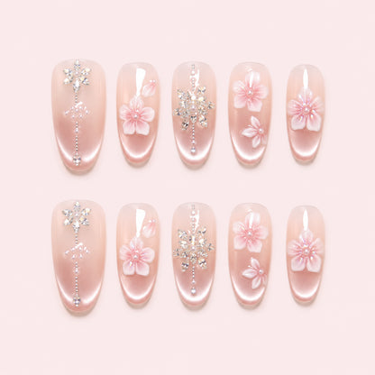 Petal Chandelier is a handmade satin pearl medium oval press-on nail set in pink, white, silver, featuring layered flowers and rhinestone botanical details, flat lay