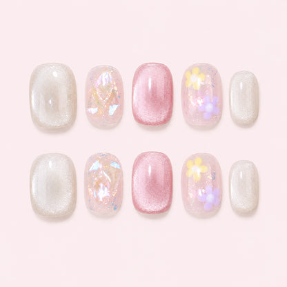 Petal Sprinkles is a handmade iridescent glossy short squoval press-on nail set in pink, white, clear, yellow, purple, featuring small flowers, shimmer and iridescent fragments, flat lay