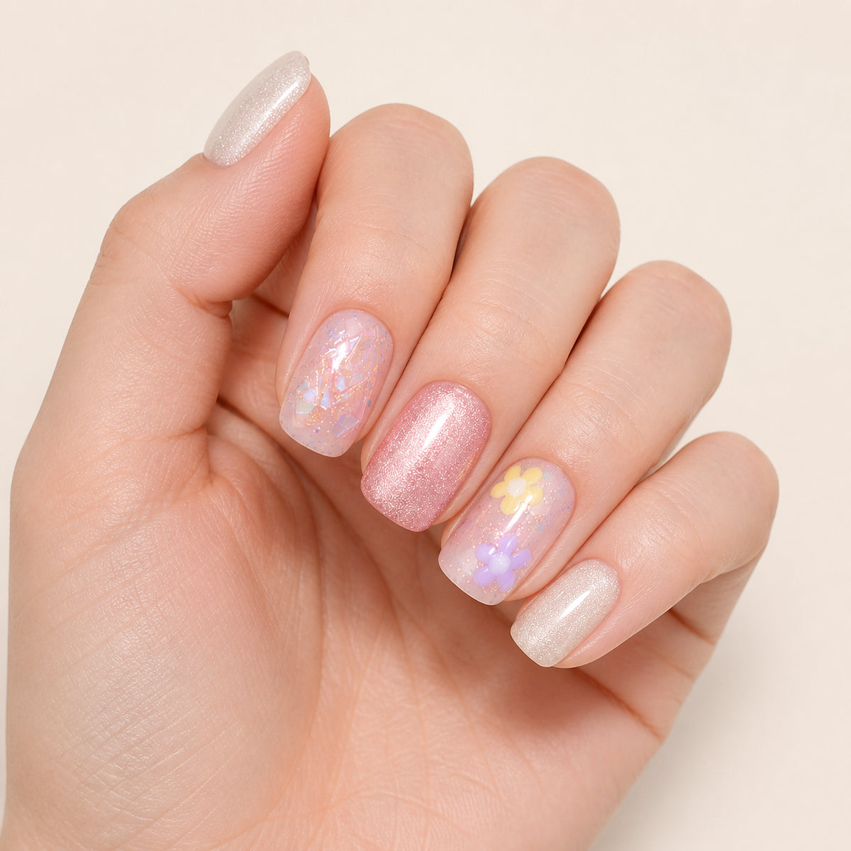 Petal Sprinkles press-on nails shown on light-skinned one hand