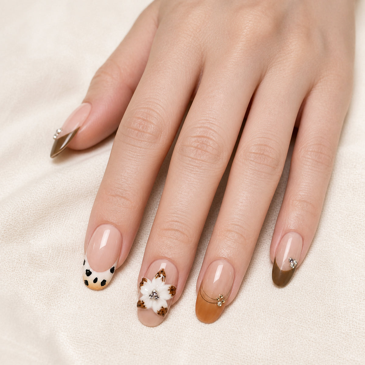 Spotted Magnolia press-on nails shown on light-skinned one hand