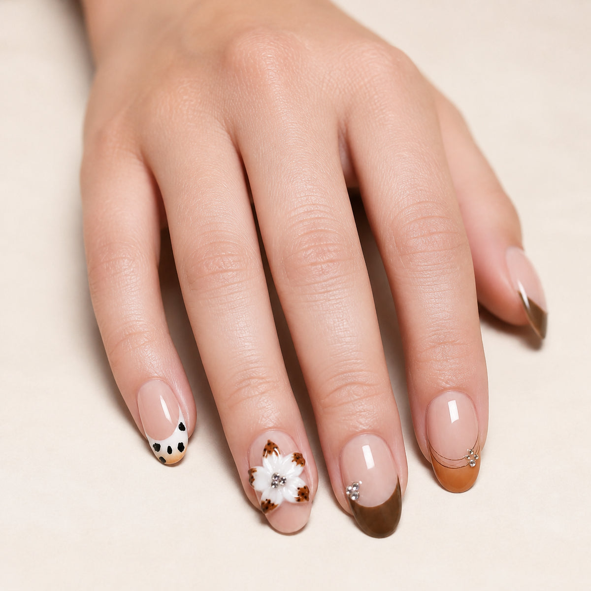 Spotted Magnolia press-on nails shown on light-skinned one hand