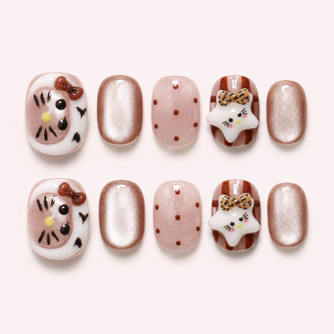Toffee Kitty press-on nails in caramel, blush and champagne shimmer with 3D cat faces, leopard-print bows and polka dots, flat lay