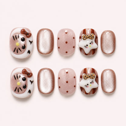Toffee Kitty press-on nails in caramel, blush and champagne shimmer with 3D cat faces, leopard-print bows and polka dots, flat lay