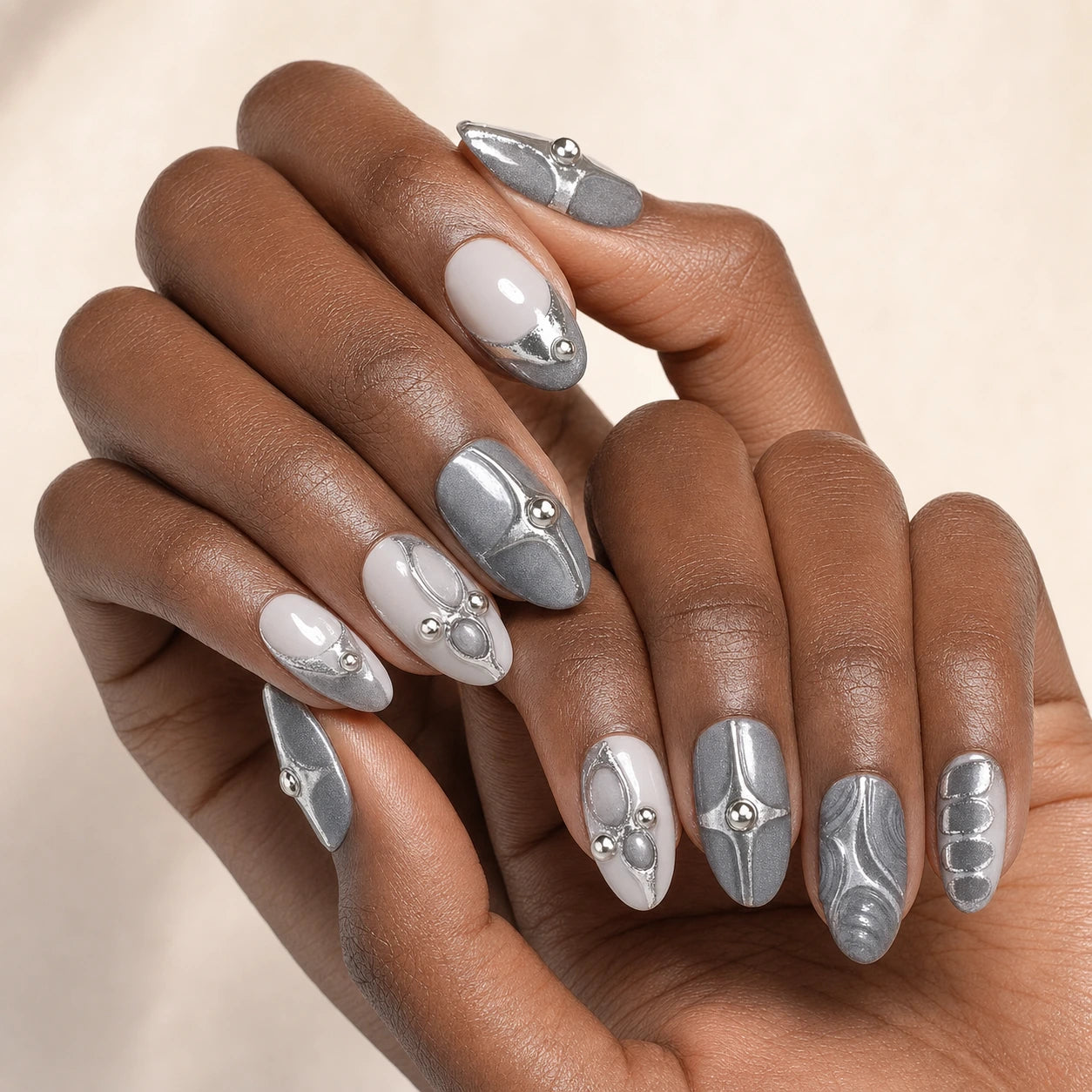 Mercury Reliquary silver grey medium almond press-on nails on two medium-brown hands