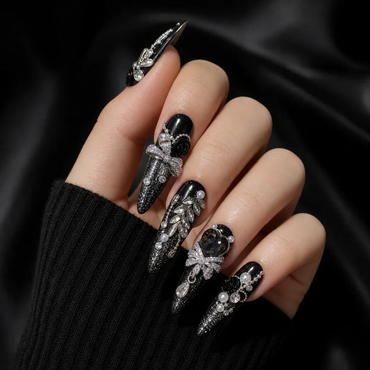Midnight Heirloom silver bow and smoky gem manicure on one curled hand