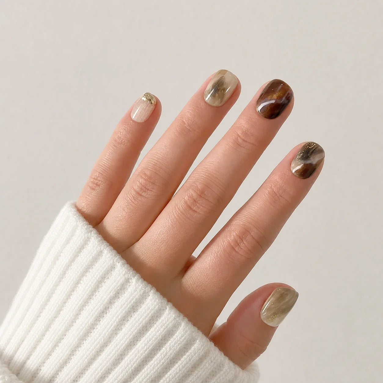 Molten Mocha coffee marble nails on one open hand