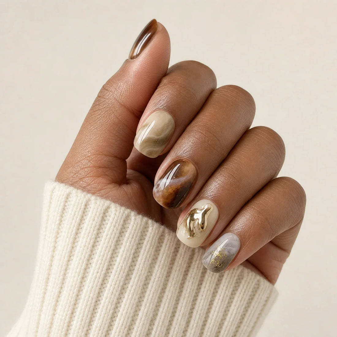 Molten Mocha cat eye manicure on one medium-brown hand